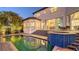 Beautiful backyard pool and spa with outdoor seating and a peek into the home's interior at 551 Ranger Ln, Longboat Key, FL 34228