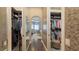 Hallway view of the walk-in closet with custom shelves and wardrobe storage and a view of the ensuite at 551 Ranger Ln, Longboat Key, FL 34228