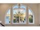 Window with palm tree and neighborhood view, under decorative light fixture at 551 Ranger Ln, Longboat Key, FL 34228
