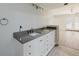 Bathroom with double sink vanity, storage cabinets, and stone countertop at 5604 Doral Dr, Sarasota, FL 34243
