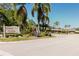 Welcoming entrance to Fairway Six Woodlake community with beautiful trees and blue skies above at 5604 Doral Dr, Sarasota, FL 34243