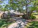 Charming home with a long driveway and mature tree providing shade at 5604 Doral Dr, Sarasota, FL 34243