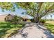 Charming home with a long driveway and mature tree providing shade at 5604 Doral Dr, Sarasota, FL 34243