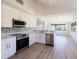 Modern kitchen with stainless steel appliances, white cabinets, and stylish backsplash at 5604 Doral Dr, Sarasota, FL 34243