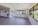 Spacious living room featuring gray wood-look floors, large windows, and modern ceiling fan at 5604 Doral Dr, Sarasota, FL 34243
