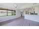 Bright, open-concept living room features large windows and gray wood-look floors at 5604 Doral Dr, Sarasota, FL 34243