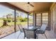 Screened-in patio with dining set, ceiling fan, and picturesque views of the expansive backyard and greenery at 5604 Doral Dr, Sarasota, FL 34243