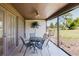 Covered patio featuring outdoor dining set and ceiling fan, with scenic views of the landscaped backyard at 5604 Doral Dr, Sarasota, FL 34243