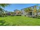 Expansive backyard featuring well-maintained lawn, mature trees, and glimpses of neighboring properties at 5723 Title Row Dr, Bradenton, FL 34210