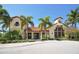 Stunning clubhouse featuring classic Mediterranean architecture, lush landscaping and beautiful palm trees at 5723 Title Row Dr, Bradenton, FL 34210