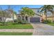 Charming two-story home with well-manicured lawn, lush landscaping, and a brick-paved driveway at 5723 Title Row Dr, Bradenton, FL 34210