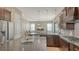 Gourmet kitchen with stainless steel appliances, an island, granite counters and a view to the living room at 5723 Title Row Dr, Bradenton, FL 34210