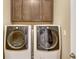 Convenient laundry room with front-load washer and dryer, and dark brown cabinets for storing supplies at 5723 Title Row Dr, Bradenton, FL 34210
