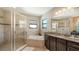 Bright main bathroom features a glass shower, soaking tub, and granite countertops at 5723 Title Row Dr, Bradenton, FL 34210