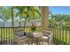 Cozy outdoor patio with a round table, cushioned chairs, and a potted plant creating a serene setting at 5723 Title Row Dr, Bradenton, FL 34210