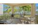 Relaxing patio with comfortable seating, a grill, and views of lush greenery and swaying palm trees at 5723 Title Row Dr, Bradenton, FL 34210