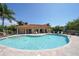Community pool featuring spacious deck with lounge chairs and adjacent clubhouse with a terracotta roof at 5723 Title Row Dr, Bradenton, FL 34210