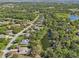 Picturesque aerial view showcasing homes with private pools in a verdant neighborhood, bordering a tranquil lake at 610 147Th St E, Bradenton, FL 34212