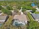 Beautiful aerial view of a charming home with a screened pool, lush greenery, and a lake in a serene neighborhood at 610 147Th St E, Bradenton, FL 34212