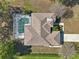 Birds-eye view of the beautiful house highlighting the roof, screened pool, driveway and green lawns at 610 147Th St E, Bradenton, FL 34212