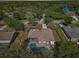 Aerial view of a home with a screened-in patio and a swimming pool, surrounded by green trees and foliage at 610 147Th St E, Bradenton, FL 34212