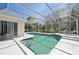 Relaxing screened pool with blue tile accents, surrounded by a spacious patio and access to the home's interior at 610 147Th St E, Bradenton, FL 34212