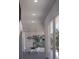 Bright, modern hallway with large windows, a dining area, and stylish light fixtures at 610 Hibiscus Way, Longboat Key, FL 34228