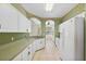 A neutral eat in kitchen and bar area features tile flooring, white cabinets, and an open feel at 6412 Rosefinch Ct # 102, Lakewood Ranch, FL 34202