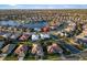High angle view captures an expansive neighborhood surrounding a serene lake with diverse roof designs at 664 Silk Oak Dr, Venice, FL 34293