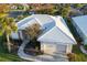 Aerial view of house featuring mature landscaping, sidewalks, and a two car garage at 664 Silk Oak Dr, Venice, FL 34293