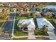 An aerial view of a community with well-maintained lawns and white roofs, near a lake at 664 Silk Oak Dr, Venice, FL 34293