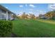 The backyard features green grass and nice landscaping with mature bushes at 664 Silk Oak Dr, Venice, FL 34293