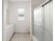 Well-lit bathroom featuring a vanity, shower with glass doors, and neutral tile flooring at 664 Silk Oak Dr, Venice, FL 34293