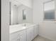 Bathroom features white cabinets, a large mirror, and a window for natural light at 664 Silk Oak Dr, Venice, FL 34293