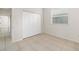 This bedroom offers a closet, window with blinds, and neutral tile floor at 664 Silk Oak Dr, Venice, FL 34293
