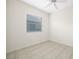 This bedroom features a ceiling fan, window with blinds, and neutral tile floor at 664 Silk Oak Dr, Venice, FL 34293