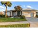Inviting home with a well manicured lawn, beautiful landscaping, and a two-car garage at 664 Silk Oak Dr, Venice, FL 34293