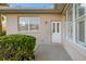 The exterior view features a white door, neat shrubbery, and a window that adds charm at 664 Silk Oak Dr, Venice, FL 34293