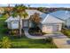 Charming home exterior boasts a lush lawn, beautiful landscaping, and a white tile roof at 664 Silk Oak Dr, Venice, FL 34293