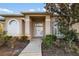 Welcoming front entrance with decorative windows, a white front door and lush landscaping at 664 Silk Oak Dr, Venice, FL 34293