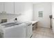 This laundry room features a washer, dryer, countertop and storage space at 664 Silk Oak Dr, Venice, FL 34293