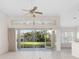 Spacious living room with a ceiling fan, decorative transom, and sliding glass doors at 664 Silk Oak Dr, Venice, FL 34293