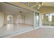 This living room opens to a screened porch with large sliding glass doors and neutral tile floors at 664 Silk Oak Dr, Venice, FL 34293