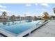 Community pool surrounded by white fence, with palm trees and neighborhood homes in the background at 664 Silk Oak Dr, Venice, FL 34293