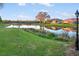 A serene waterfront view with lush greenery and neighboring houses in the backdrop at 664 Silk Oak Dr, Venice, FL 34293