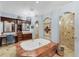 A luxurious bathroom featuring a tiled tub, walk-in shower, and vanity area at 6822 Dominion Ln, Lakewood Ranch, FL 34202