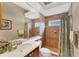 A bathroom with tiled walls, a shower with curtain, and a large mirror at 6822 Dominion Ln, Lakewood Ranch, FL 34202