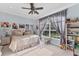 A cozy bedroom with a plush bed, a large window, and personal decor at 6822 Dominion Ln, Lakewood Ranch, FL 34202