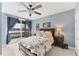 Bright bedroom featuring a ceiling fan, an area rug, and access to a covered patio with blue drapes at 6822 Dominion Ln, Lakewood Ranch, FL 34202