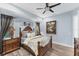 A well-lit bedroom featuring a wooden bed, soft bedding, and neutral decor at 6822 Dominion Ln, Lakewood Ranch, FL 34202
